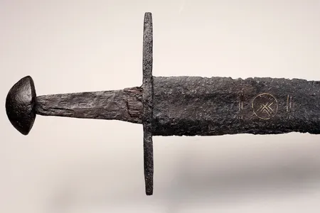The sword&#39;s hilt is made up of a six-and-a-half-inch guard, once-leather grip and nut-shaped pommel.