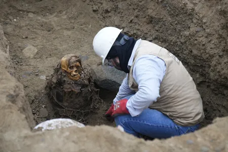 Jose Aliaga, an archaeologist with the gas company C&aacute;lidda, excavates the mummy in Lima, Peru.