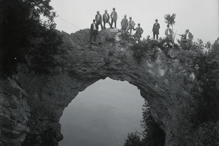 Visitors pose atop Arch Rock, a geological formation on Mackinac Island