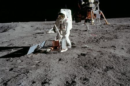 Apollo 11 astronaut Buzz Aldrin deploys a device to detect moonquakes during the first moonwalk.