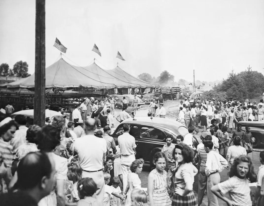 Survivors of the Hartford circus fire watch as smoke rises from a tent.