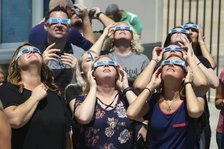 Texas Motor Speedway staff watch the August 21, 2017, total solar eclipse through special eclipse glasses.